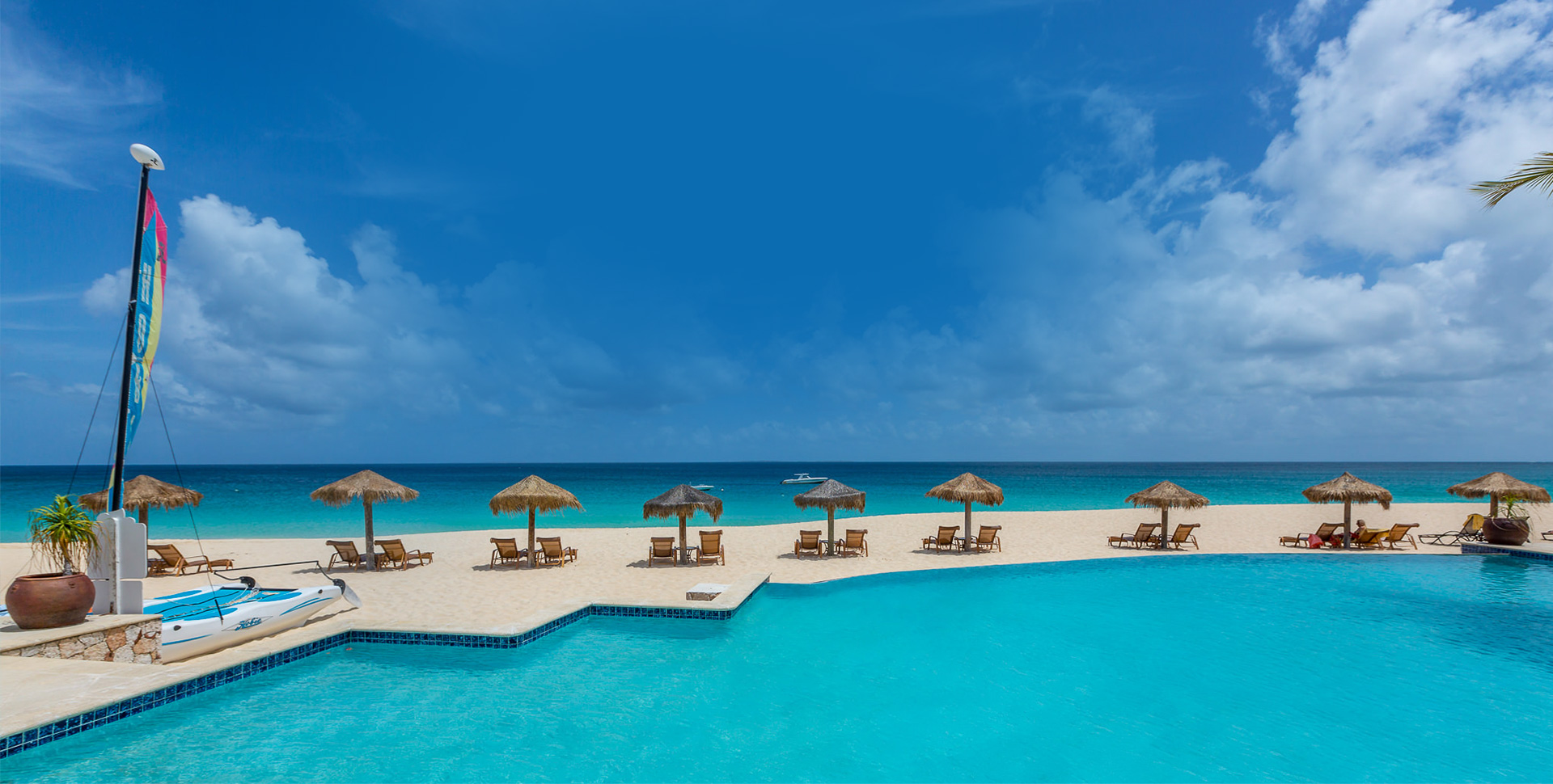 The beachfront pool and white-sand beach at Frangipani Beach Resort